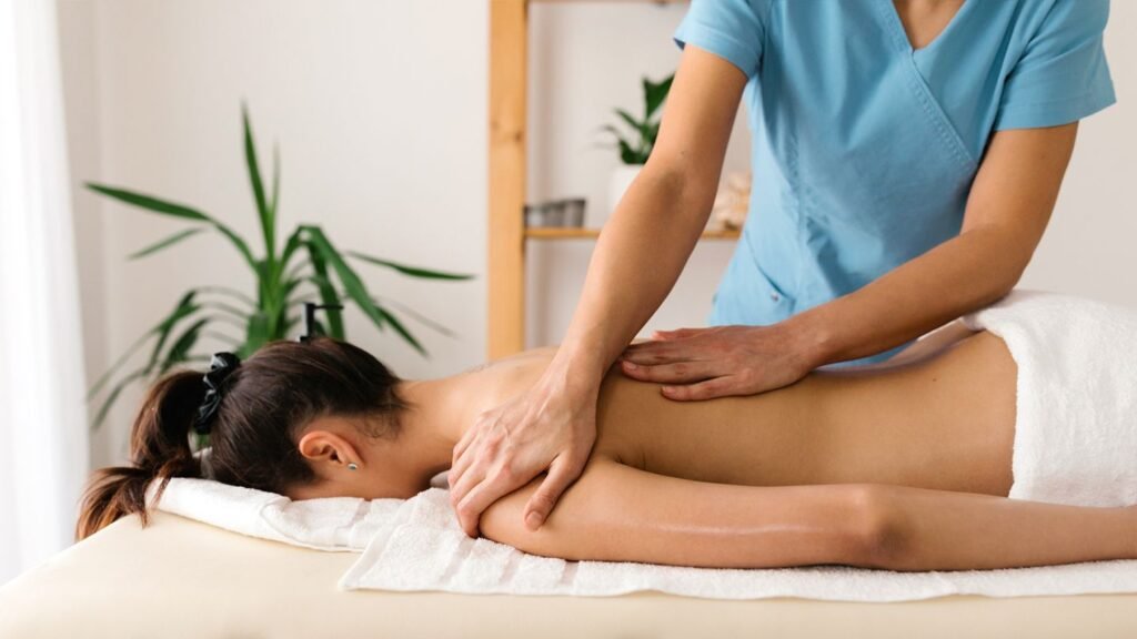 "A peaceful spa scene highlighting a massage therapist delivering a calming back massage, emphasizing the harmony of massage and facial services for stress relief and radiant skin."